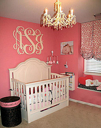 Elegant watermelon pink and black baby girl nursery room with custom wooden wall letters and baby bedding