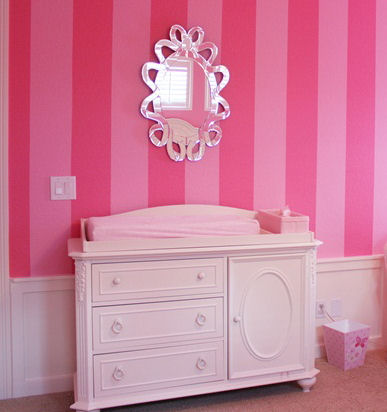 Antique dresser changing table in a pink baby girl nursery room