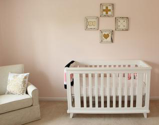 An elegant baby girl nursery room with blush pink wall paint color