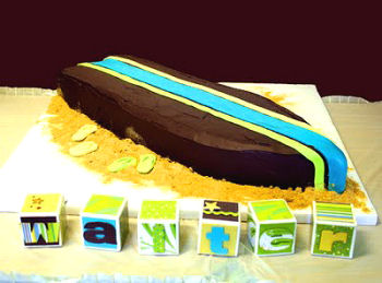 Chocolate surfboard shaped beach theme baby shower cake with ganache frosting and buttercream filling