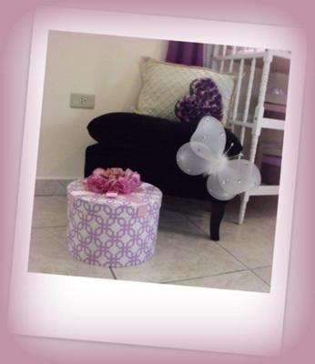 A comfortable chair and a black velvet ottoman give this baby girl's purple vintage princess nursery room a royal touch.