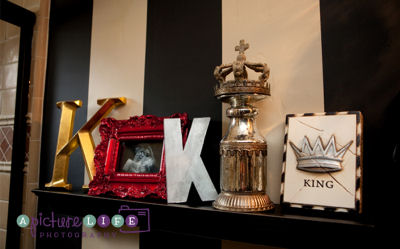 King themed decorations arrangement on a shelf in the baby boy nursery room with painted wall stripes