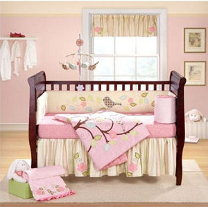 Pink baby bedding crib set for a pink and yellow baby girl nursery with bird mobile applique birds on the quilt and bumper