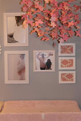 Photos and artwork in a wall display over the baby changing table